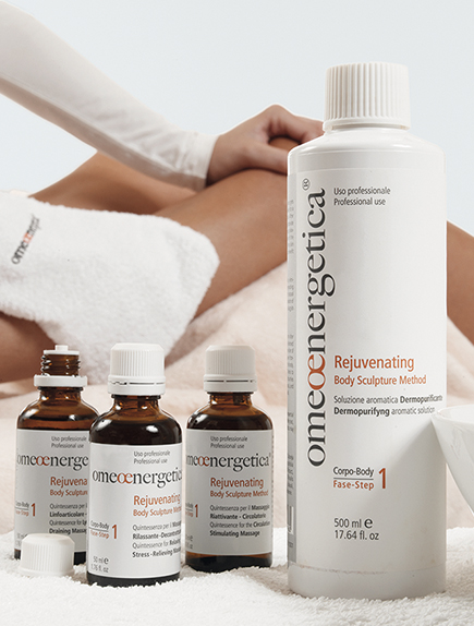 Gros plan sur la gamme professionnelle Omeoenergetica pour la méthode de remodelage corporel rajeunissante. Présentation de la solution aromatique dermo-purifiante et des flacons pour le massage sur la zone du fascia.